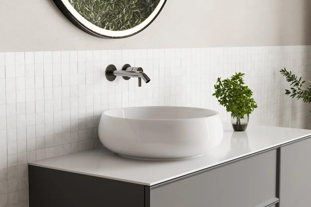 White vessel basin on a pale stone vanity against a tiled wall