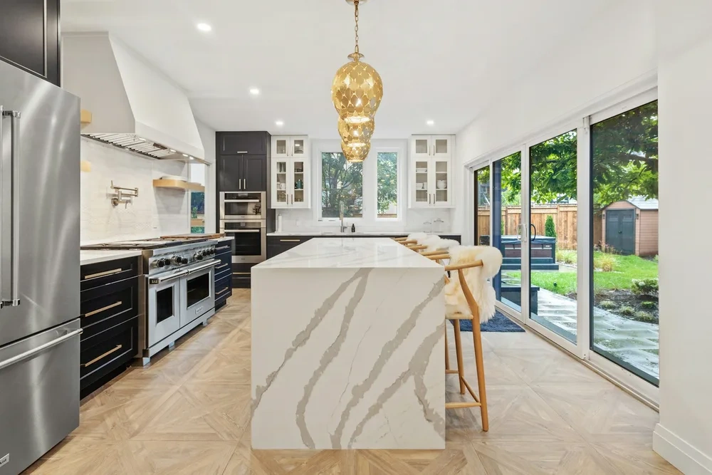 Marble waterfall island lit by a brass pendant