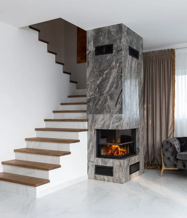 Stone-clad staircase beside a full-height fireplace surround